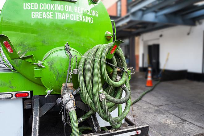 a service truck pumping grease from a restaurant's grease trap in Algona